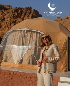 eine Frau, die vor einem Zelt steht in der Unterkunft BUBBlES JOHRH LUXURY CAMP in Disah
