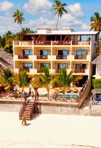 ein Hotel am Strand mit Palmen in der Unterkunft Tangawizi Lodge Zanzibar - Adults Only in Jambiani