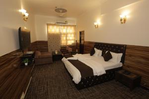 a bedroom with a bed and a couch and a television at Hotel Kuber in Rāi