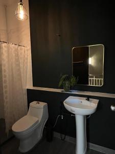 Un baño con inodoro, lavabo y espejo. en Resilience 9, en Kota Kinabalu