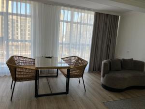 a living room with a table and chairs and a couch at 71 East Hotel in Astana