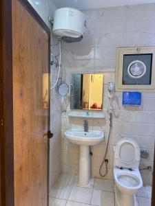 une petite salle de bain avec toilettes et lavabo dans l'établissement شقق نورسين ان للشقق المخدومة, à Quai