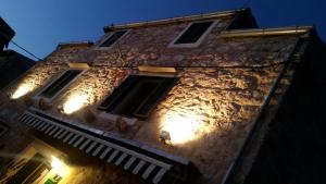 an old building with lights on it at night at Buena Vis-ta Apartments with the Sea View in Vis