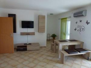a living room with a table and a tv in it at Apartmani Gagi in Vir