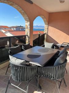 a table and chairs on a balcony with a view at Apartmani Gagi in Vir