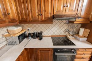 a kitchen with wooden cabinets and a counter top at Dandy Villas Tsagkarada - Sky Blue Pansy - Jacuzzi in Tsagarada +42 photos