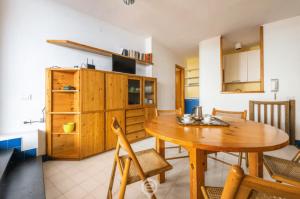 Una cocina y un comedor con mesa y sillas de madera. en Waterside Oasis House, en Villasimius 21 fotos más