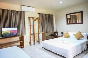 a hotel room with two beds and a flat screen tv at Bulskamp Inn in El Nido +59 photos
