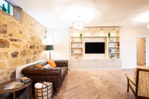 a living room with a couch and a tv at Northern Hideaways The Old Chapel, Otterburn in Otterburn