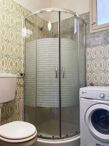 ein Bad mit einer Dusche, einem WC und einer Waschmaschine in der Unterkunft Ulisse apartment on the sea in Punta Secca