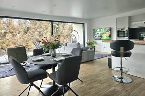 a living room with a table and chairs and a kitchen at Stilvolle Wohnung mit Blick und Selbst-Check-in in Bad Berleburg