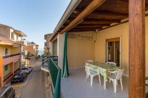 einen Balkon mit einem Tisch und Stühlen darauf in der Unterkunft Ulisse apartment on the sea in Punta Secca