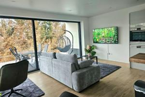 un salon avec un canapé et une cuisine dans l'établissement Stilvolle Wohnung mit Blick und Selbst-Check-in, à Bad Berleburg