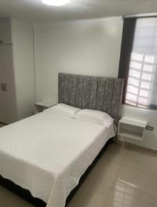 a bedroom with a large bed with white sheets and a window at Great for Relaxing in SC in San Cristóbal
