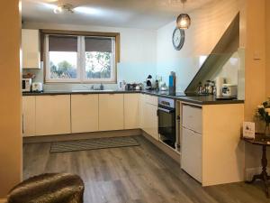 a kitchen with white cabinets and a clock on the wall at The Wee Pad - Uk42918 in Dunfermline