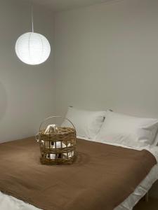 首尔stay early mansion 가산, 홍대, 고척돔的床上放着一个篮子，篮子里有一盏灯。