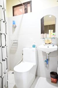 a bathroom with a toilet and a sink at Bulskamp Inn in El Nido