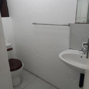 ein weißes Badezimmer mit Toilette und Waschbecken in der Unterkunft Ocean walk Dorado in Zinkwazi Beach