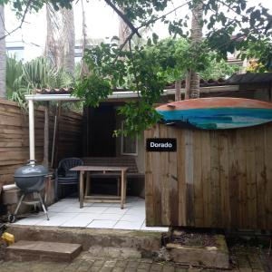 ein Holzzaun mit einem Tisch und einem Surfbrett darauf in der Unterkunft Ocean walk Dorado in Zinkwazi Beach