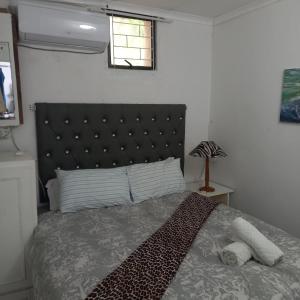 ein Schlafzimmer mit einem großen Bett mit schwarzem Kopfteil in der Unterkunft Ocean walk Dorado in Zinkwazi Beach