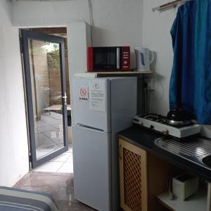 eine Küche mit Kühlschrank und Mikrowelle in der Unterkunft Ocean walk Dorado in Zinkwazi Beach