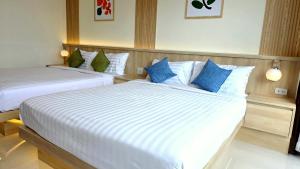 two beds in a hotel room with blue pillows at Samed Port View in Ko Samed