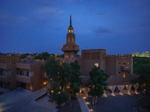 a view of a building with a clock tower at night at Turpan Rizamat Manor in Turfan