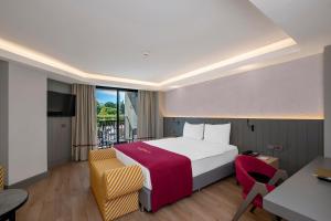 a hotel room with a bed and a balcony at The X Belek in Belek