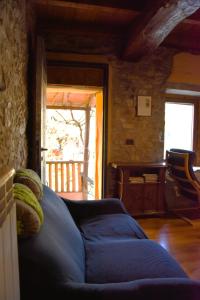 un salon avec un canapé bleu devant une porte dans l'établissement Casale Mansano - Natura e relax nelle colline, à Vigolzone 116 autres photos