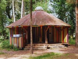 une cabane colorée au toit de chaume dans les bois dans l'établissement Westacre 4 Ton Tents, à Narborough 11 autres photos