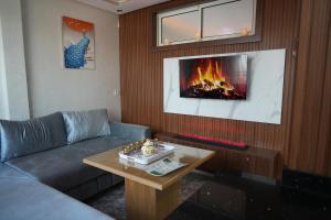 a living room with a couch and a fireplace at APPARTEMENT AMJAD iFRANE in Ifrane