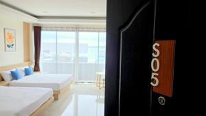 a hotel room with two beds and a window at Samed Port View in Ko Samed