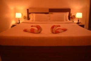 two towels on a bed in a hotel room at Kohuwa Resort in Jyoti Gaon