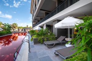 an outdoor patio with an umbrella and a swimming pool at The X Belek in Belek