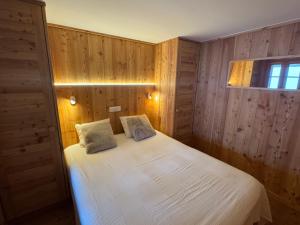 un dormitorio con una cama con dos almohadas. en Sadzot, en Grimentz