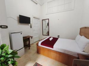 a bedroom with a bed and a tv on the wall at City House Guesthouse in Cairo