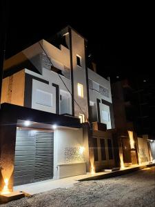ein beleuchtetes Gebäude mit einer Garage in der Nacht in der Unterkunft Charming S1 cozy modern and bright in Mahdia