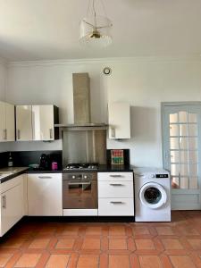 a kitchen with a stove and a washing machine at Villa Alexandre III in Dijon