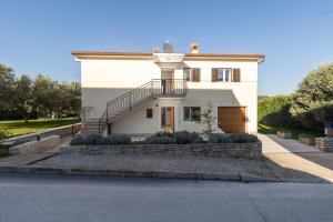 a white house with a staircase in front of it at Casa Jurican in Višnjan