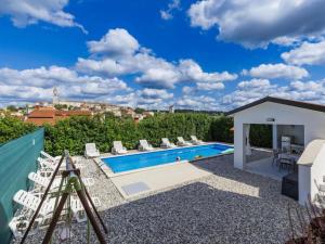 a view of a swimming pool with chairs and a building at Casa Jurican in Višnjan