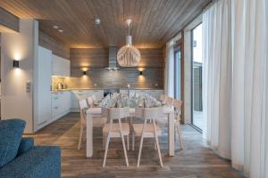 a dining room with a white table and chairs at Ski-Inn Kultakero Penthouse in Pelkosenniemi