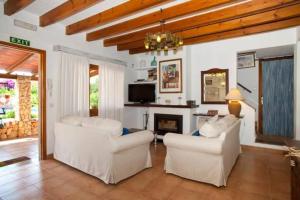 - un salon avec deux chaises blanches et une cheminée dans l'établissement Modern Villa with Private Pool in Muro 300 m², à San Lorenzo