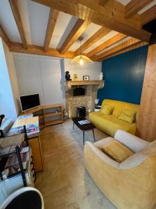 a living room with a yellow couch and a fireplace at Maisonnette au cœur des vignes in Fixin