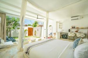 a bedroom with a large white bed and a fireplace at Marghe 1BR Romantic Villa, 5 Mins to Thomas Beach in Badung