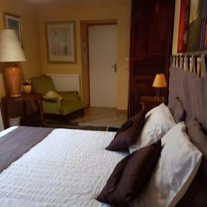 - une chambre avec un lit doté d'oreillers et d'une chaise dans l'établissement Chambre Grany - Chambre, à Aucaleuc