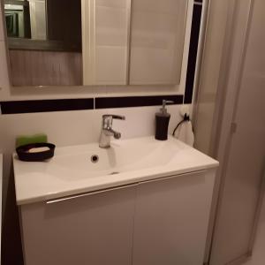 une salle de bains avec un lavabo blanc et un miroir dans l'établissement Chambre Grany - Chambre, à Aucaleuc