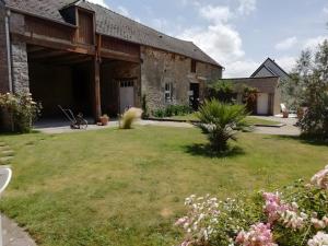 un bâtiment avec une cour fleurie devant elle dans l'établissement Chambre Grany - Chambre, à Aucaleuc