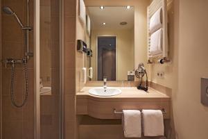 a bathroom with a sink and a shower at H+ Hotel München in Munich +39 photos
