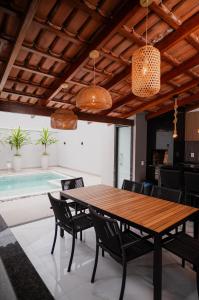 una sala da pranzo con tavolo e piscina di Bela casa de temporada em Alcobaça BA ad Alcobaça