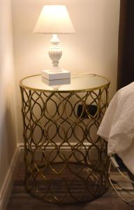 a table with a lamp on it next to a bed at San Francesco Suite in Poggio Bustone